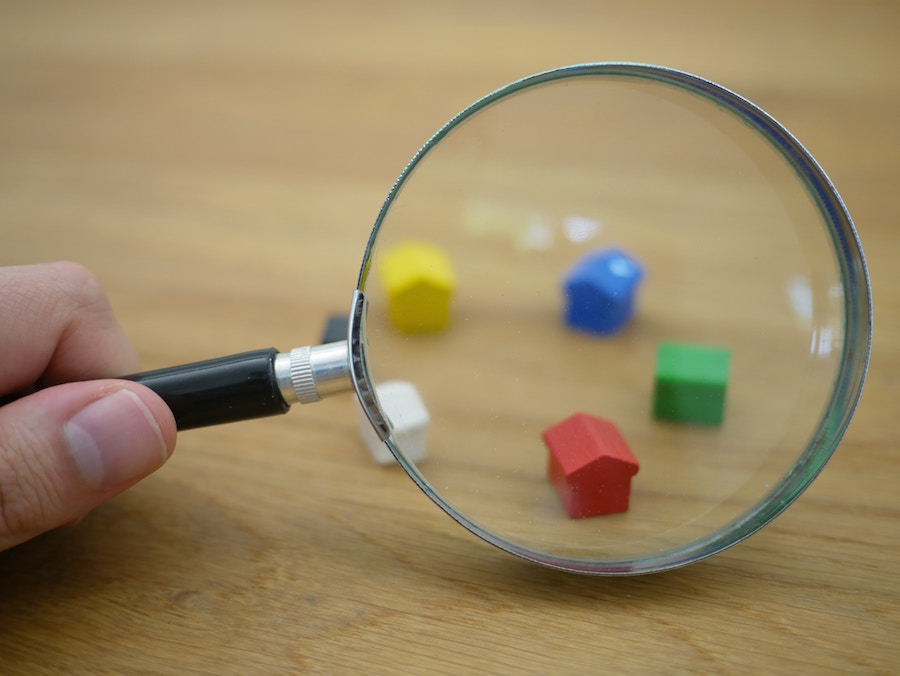 House figures with magnifying glass